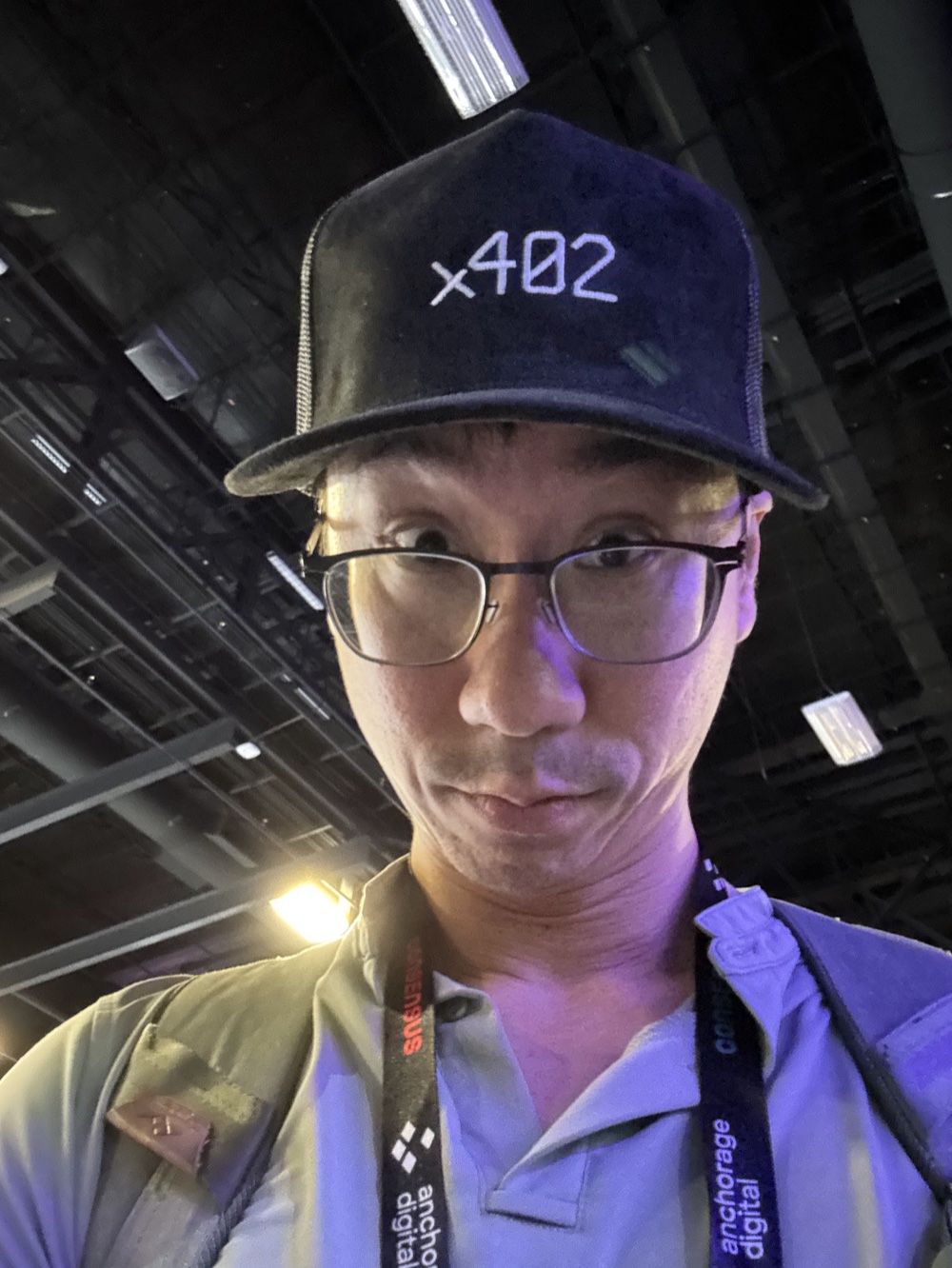 Selfie at Consensus in Miami wearing an x402 cap and an Anchorage Digital lanyard.